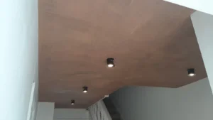 Skimmed ceiling with four recessed lights, illuminating a staircase area and white walls.