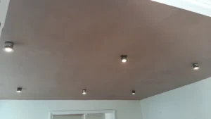 Skimmed ceiling in a room with six recessed lights, casting light over white walls.